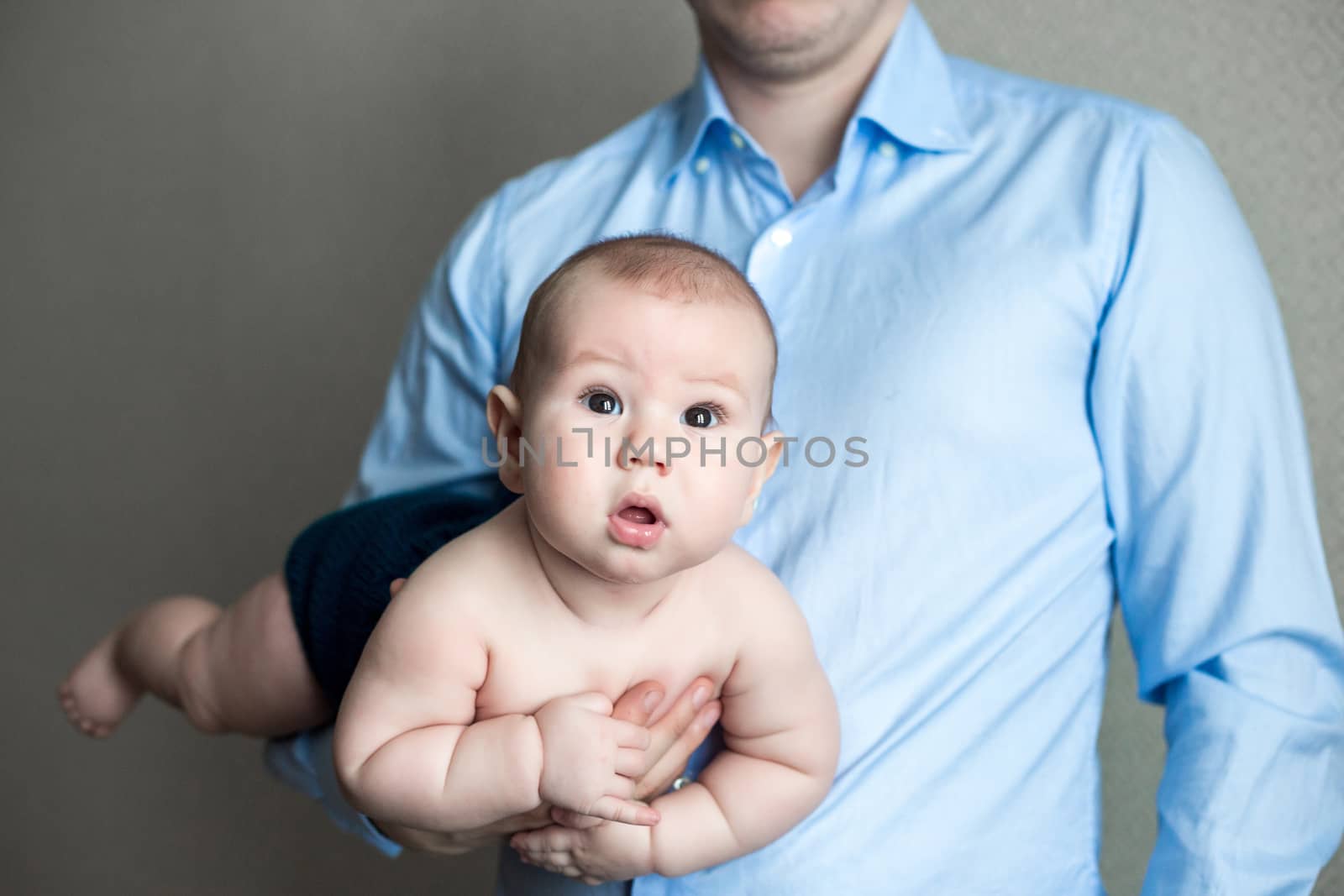 close-up portrait of a toddler boy in the arms of dad