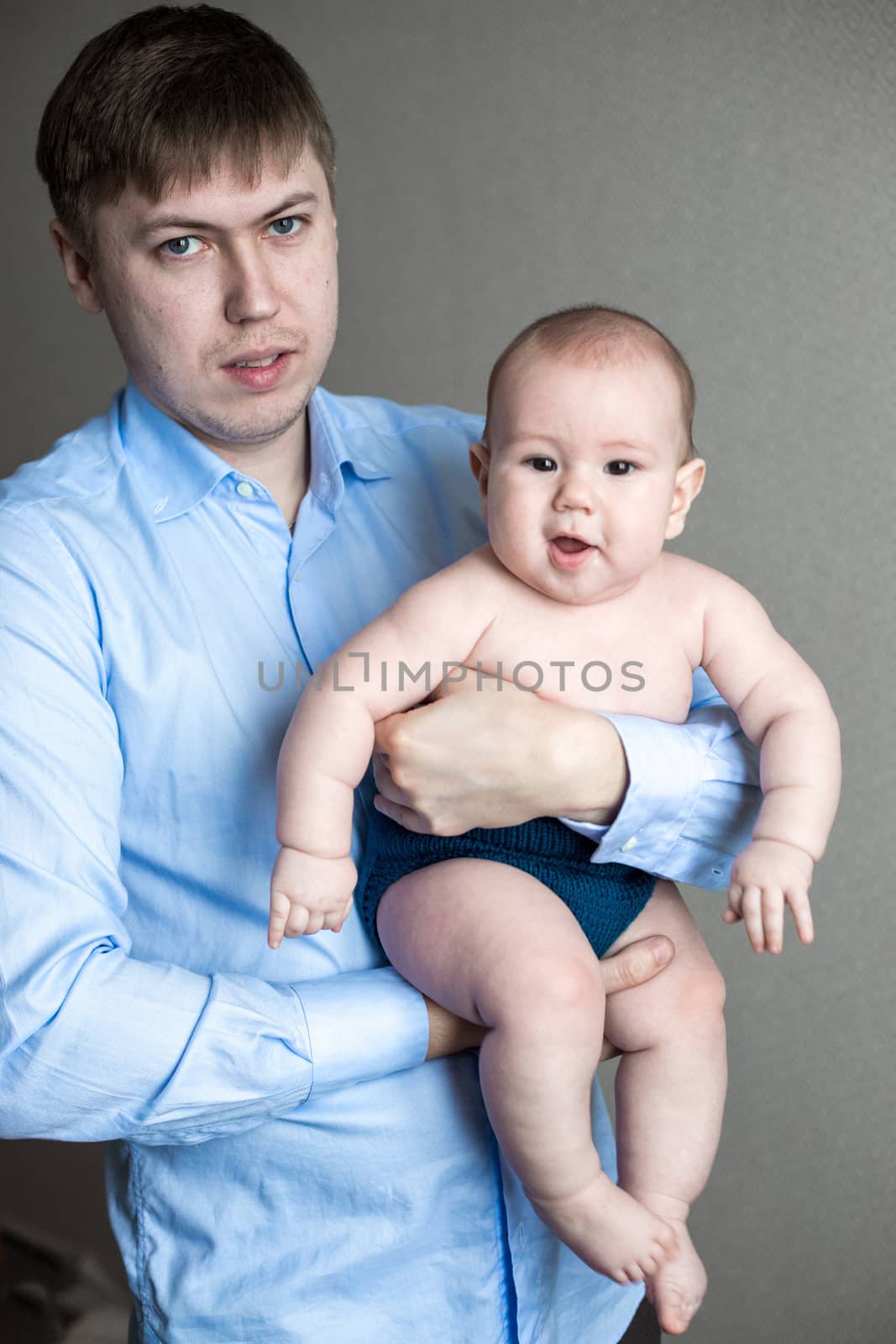 close-up portrait of a toddler boy in the arms of dad