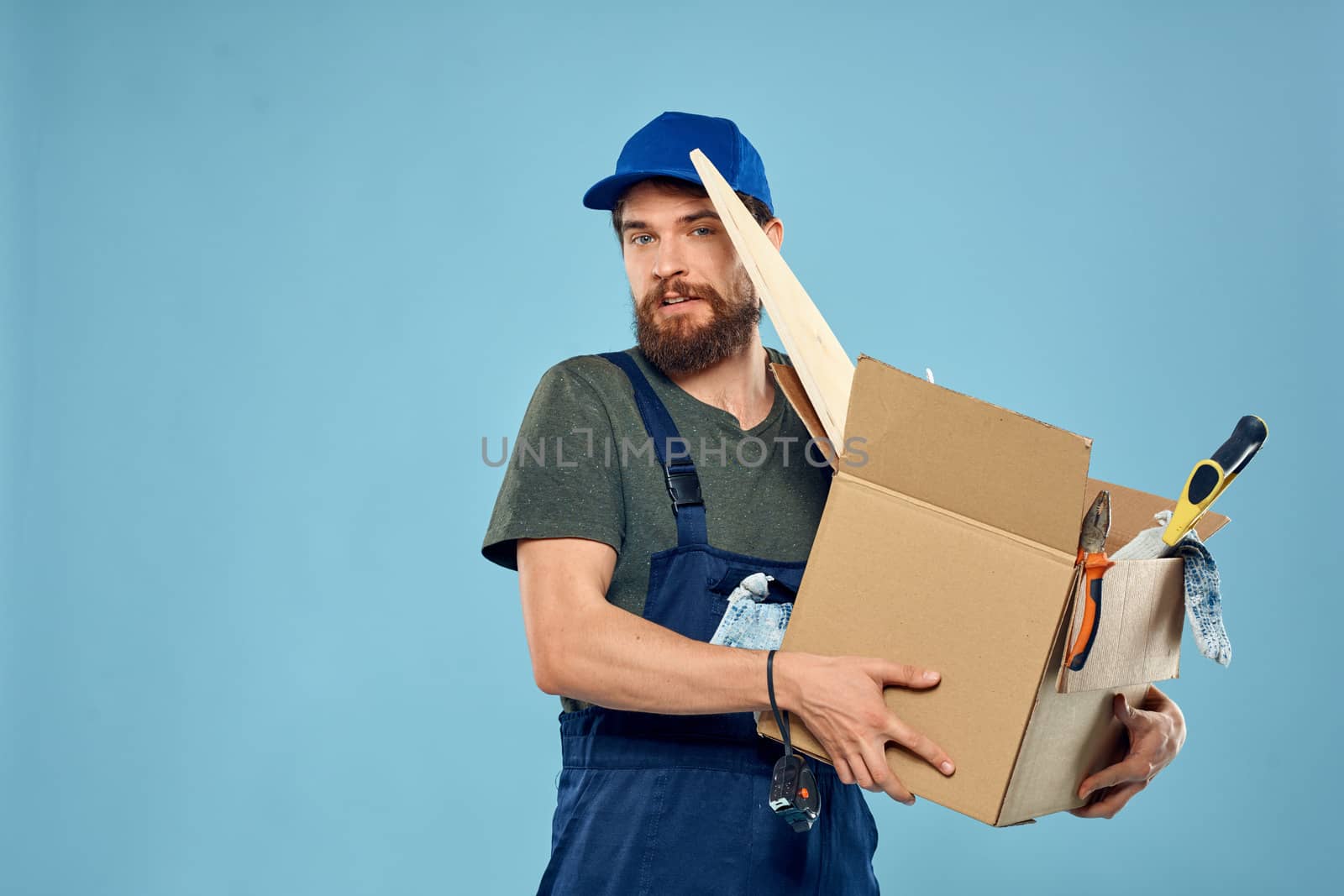 Worker man in uniform box tools construction blue background by SHOTPRIME