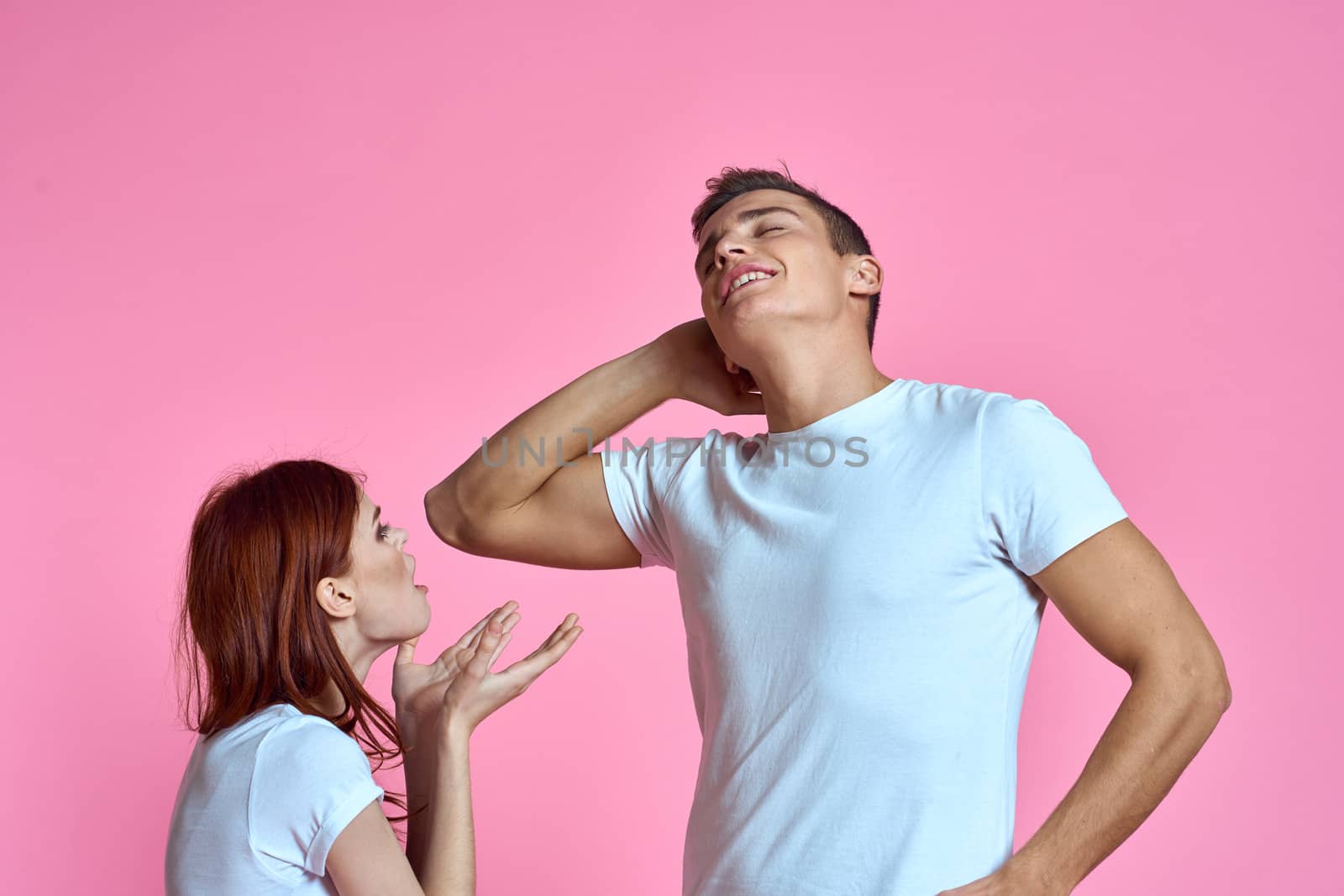 enamored man and woman hugging each other on a pink background cropped with Copy Space family portrait. High quality photo