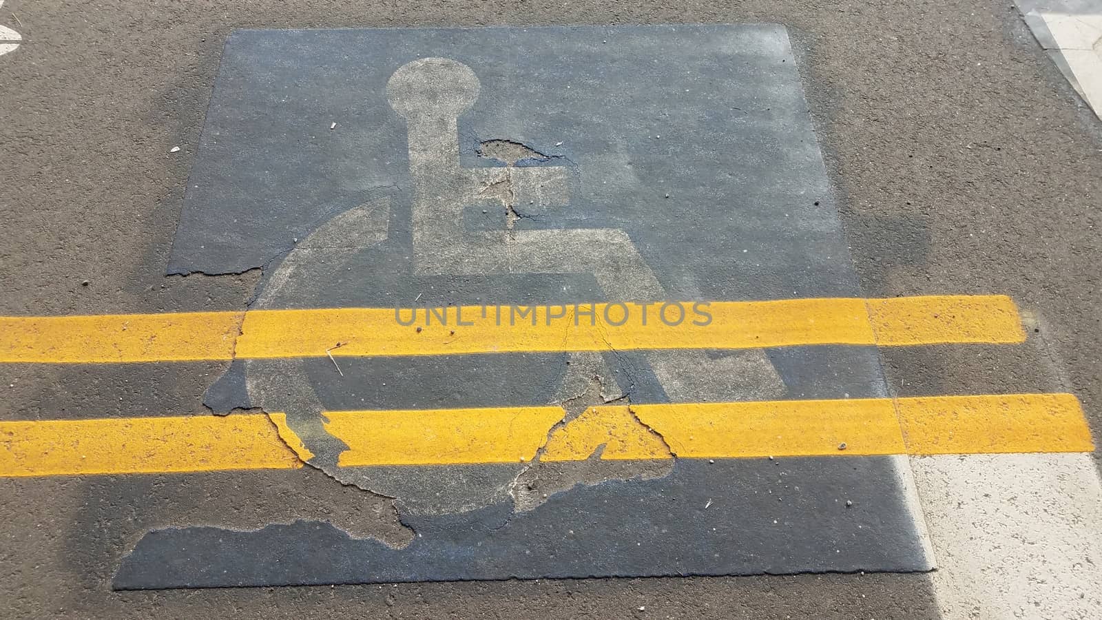old wheelchair sign with yellow lines painted over