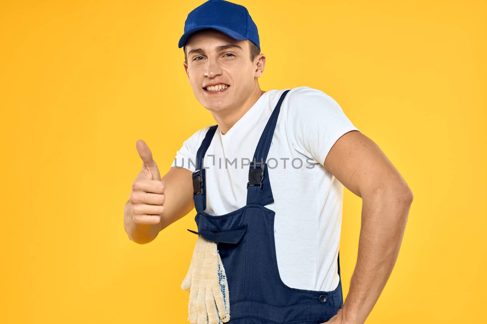 Man in working uniform emotions rendering service delivery service yellow background. High quality photo