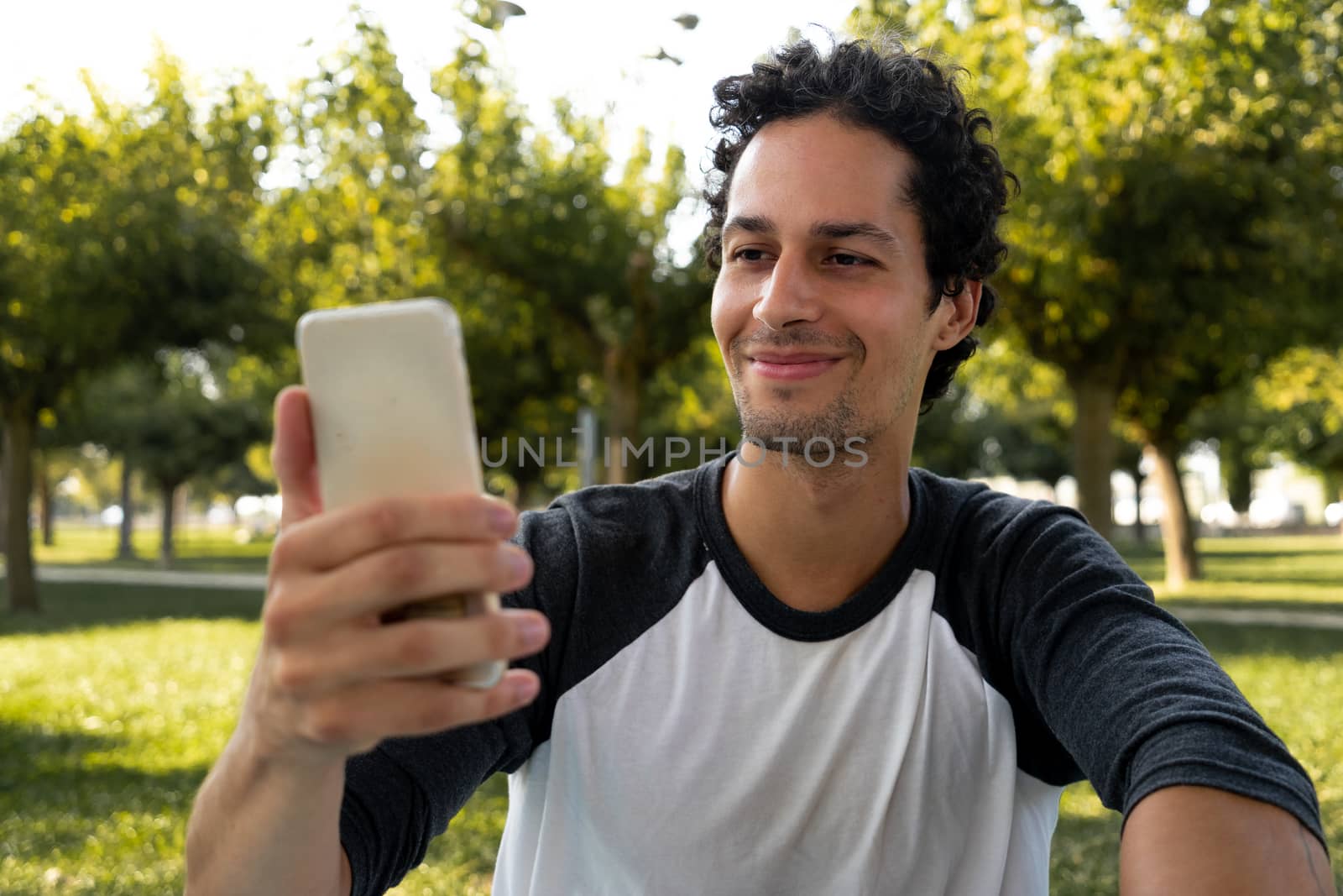 Portrait of young man using the mobile phone in the park