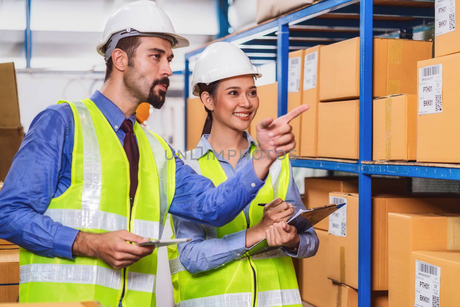 Manager of warehouse worker assign and command to assistant manager woman in local warehouse or factory, Asian and white caucasian people,barcode and QR code, Partner and colleague working together