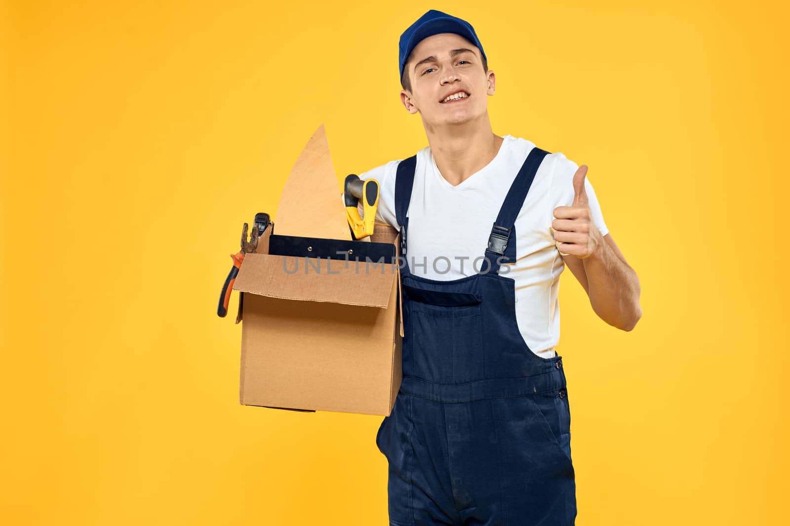 worker with box in hand tools loader yellow background by SHOTPRIME