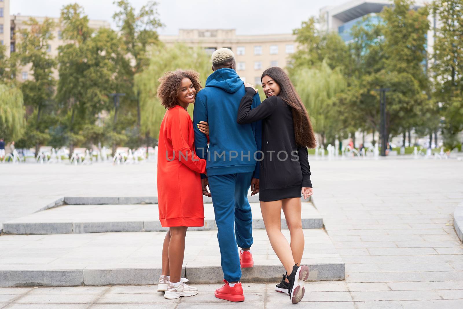Multi ethnic friends outdoor. Two woman in love with one guy Diverse group people Afro american asian spending time together Multiracial male female student walking park outdoors