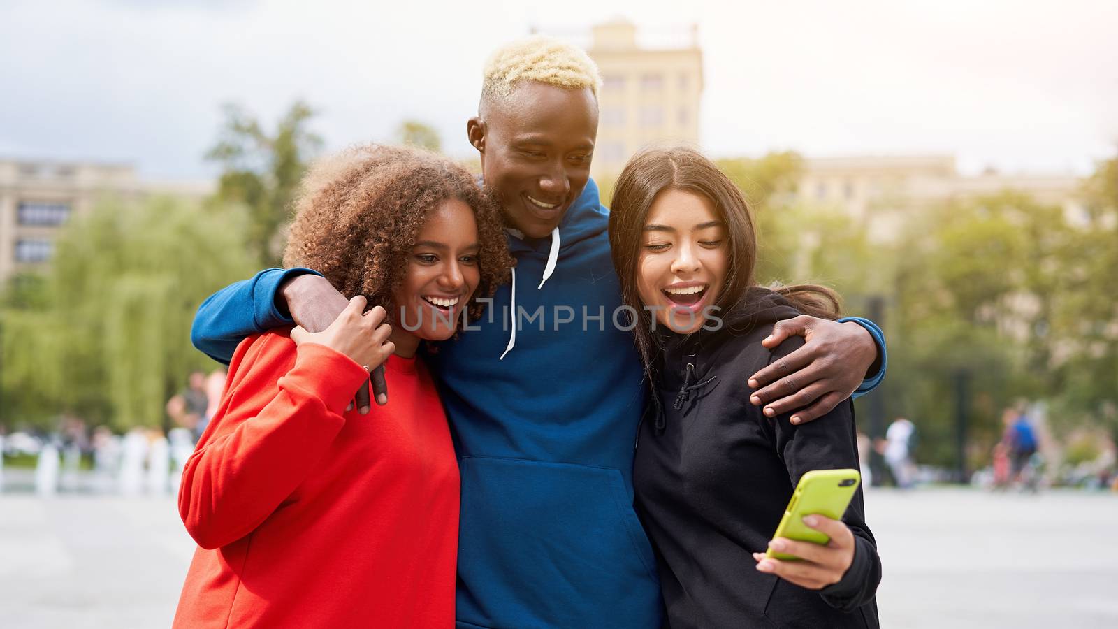 Multi ethnic friends outdoor looking smartphone screen. Diverse group people Afro american asian spending time together Multiracial male female student meeting outdoors