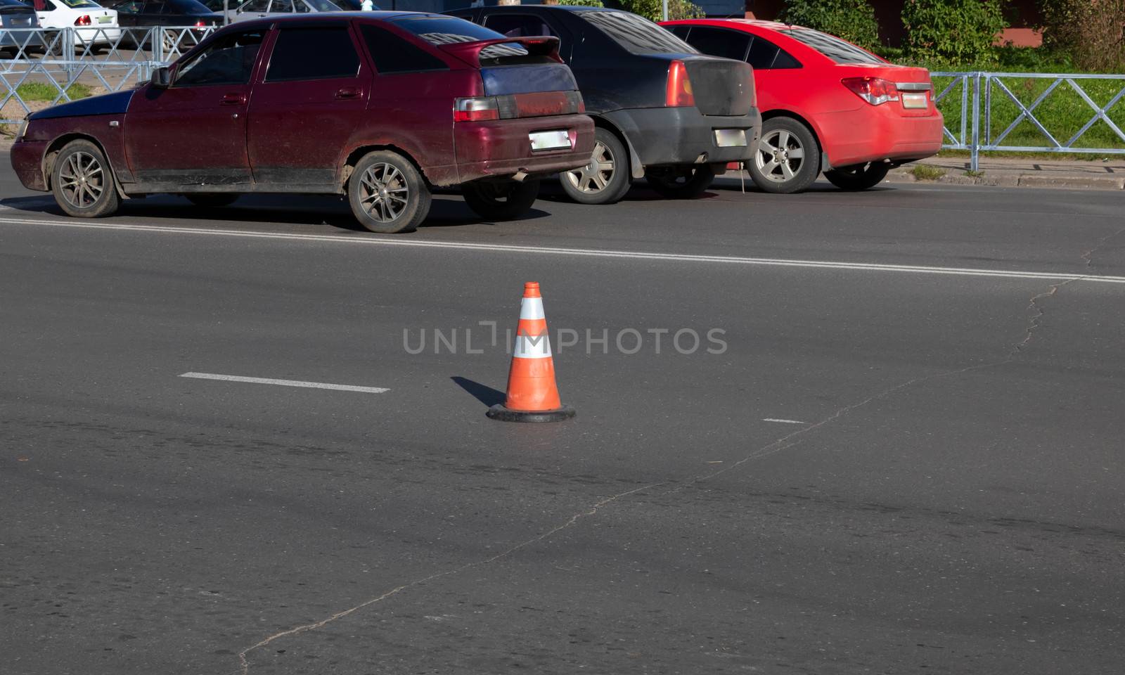 an orange traffic cone on the road indicates the path, road works, detour of a dangerous section of road, roadway repairs.
