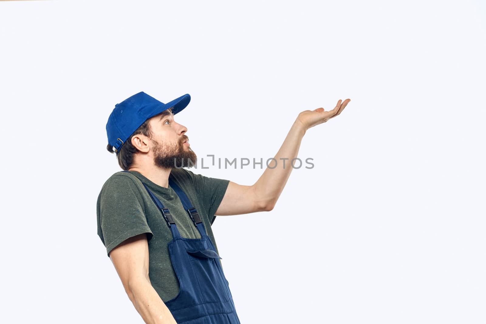 Worker man uniform delivery service emotions studio light background. High quality photo