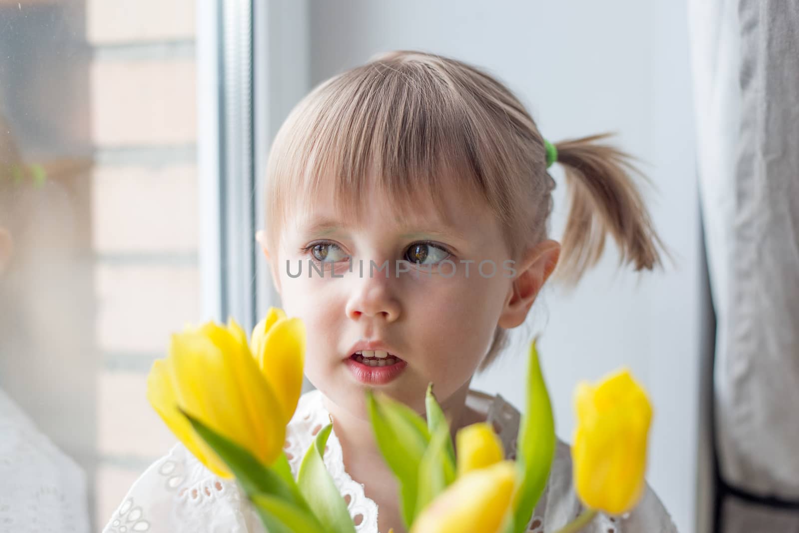 A Portrait of a beautiful little girl with a bouquet of yellow tulips flowers by galinasharapova