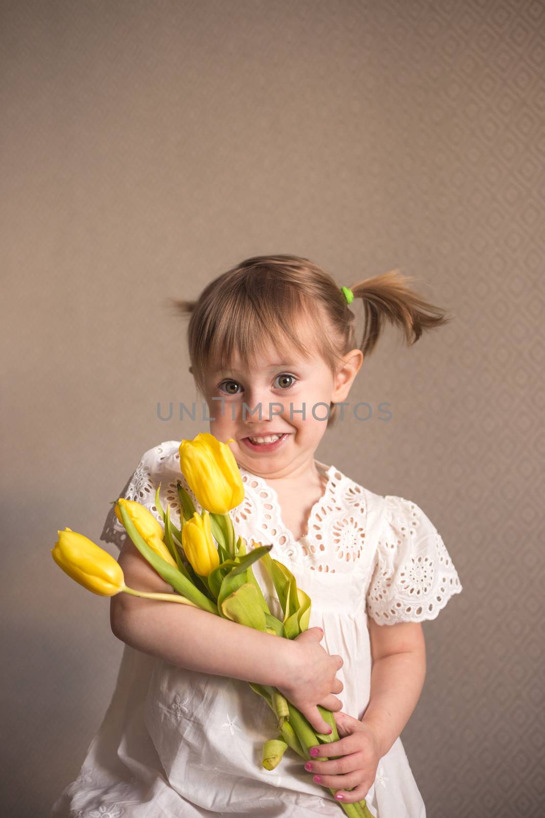  A Portrait of a beautiful little girl with a bouquet of yellow tulips flowers by 8th march international womens day