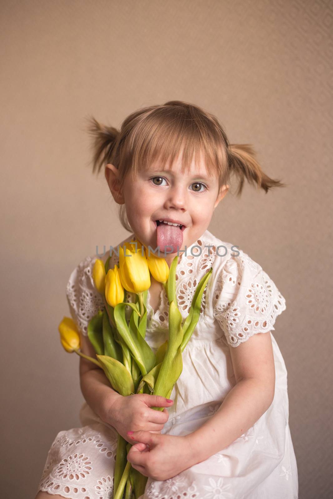 A Portrait of a beautiful little girl with a bouquet of yellow tulips flowers by galinasharapova