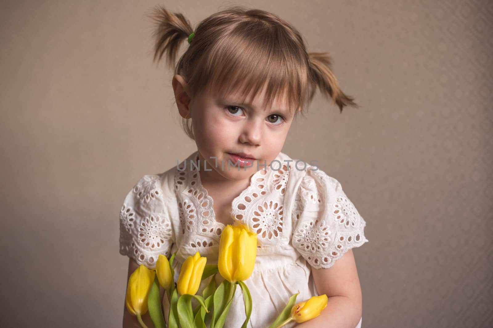  A Portrait of a beautiful little girl with a bouquet of yellow tulips flowers by 8th march international womens day