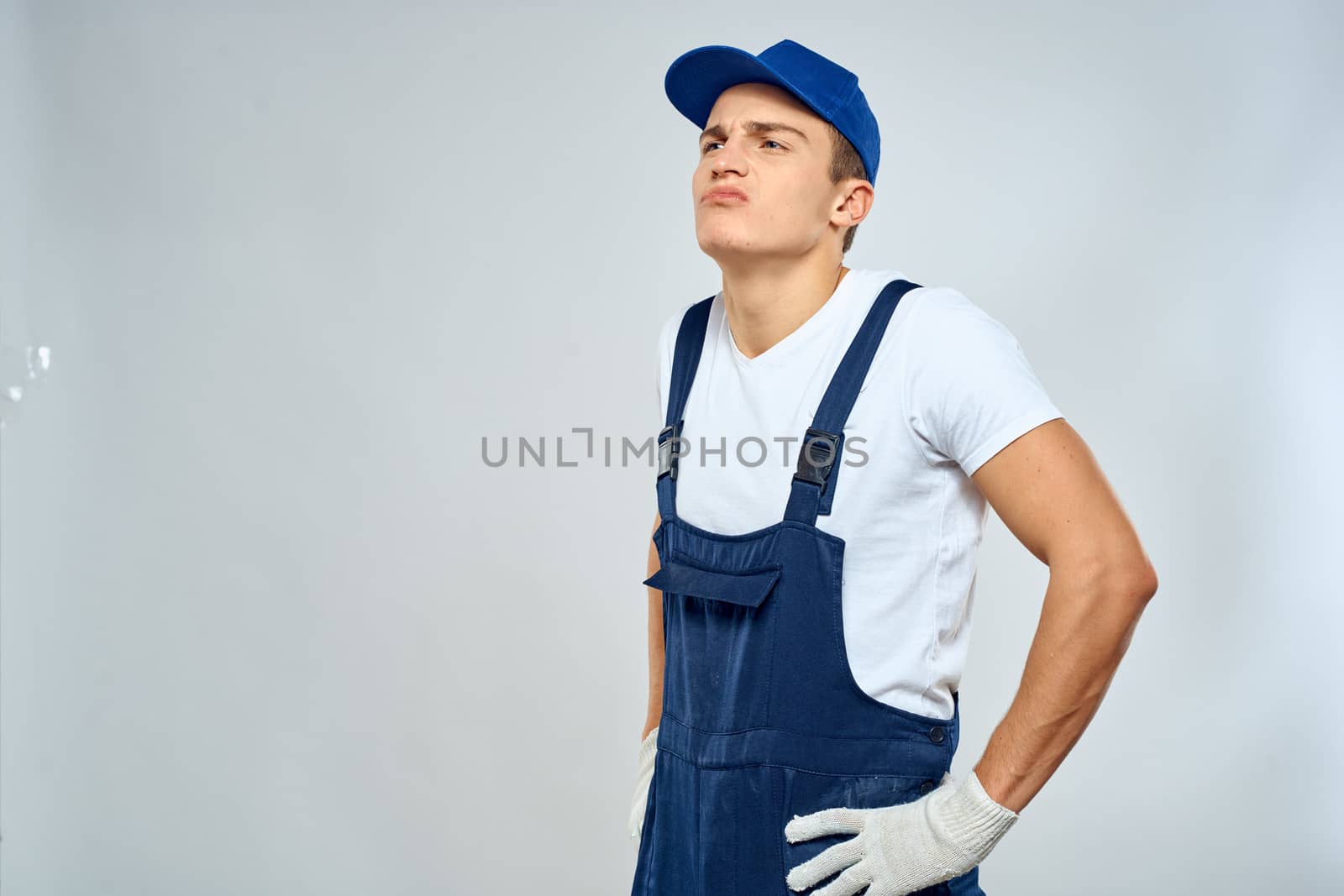 Man worker in forklift uniform delivery service light background. High quality photo