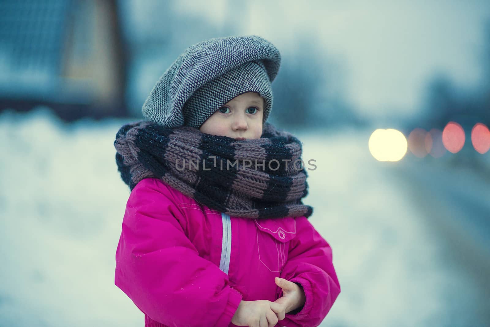 .A little girl stands in the snow by the road in the evening by galinasharapova