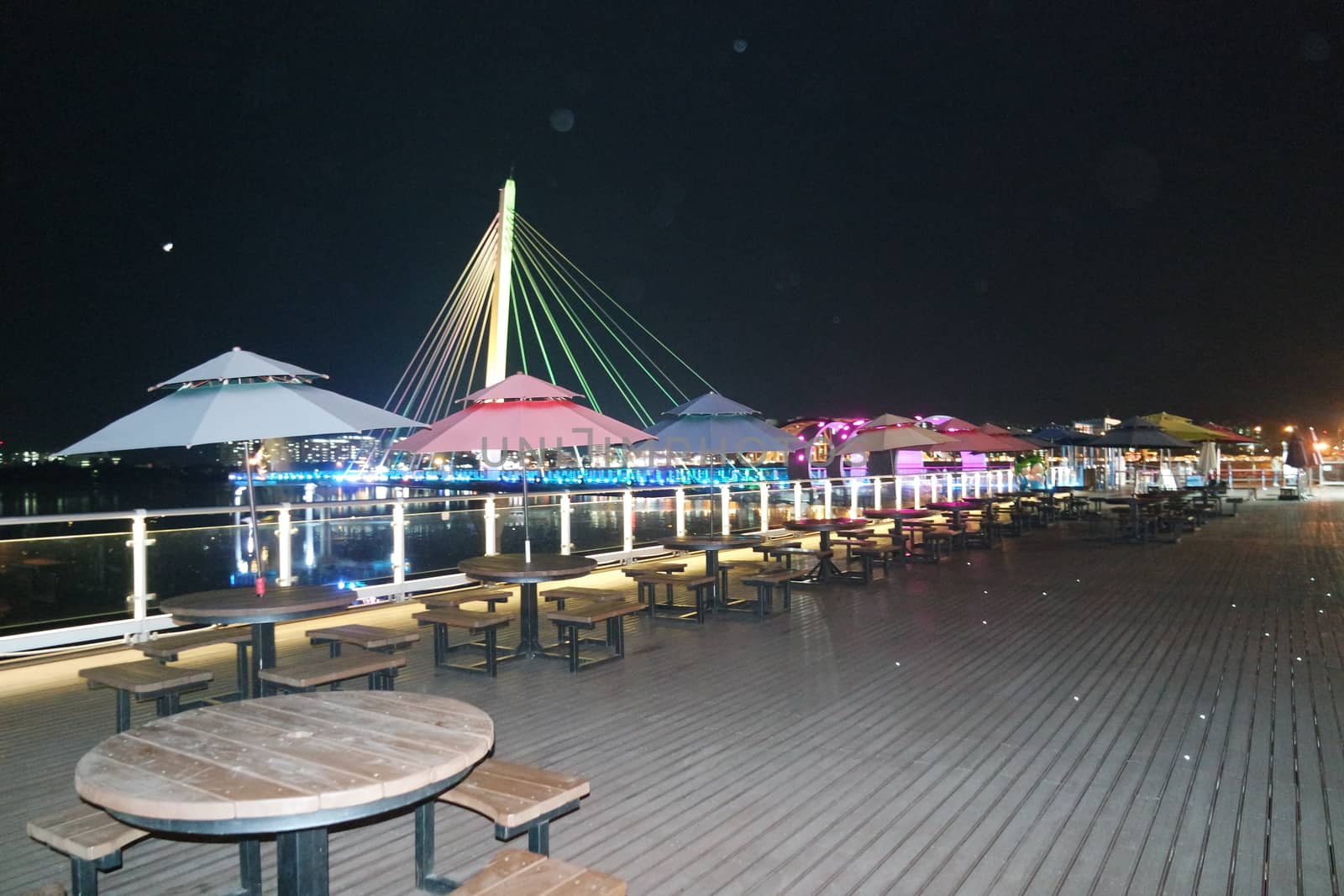 Night view of a beautiful scene of bridge over sea water in the evening time with colorful lights.