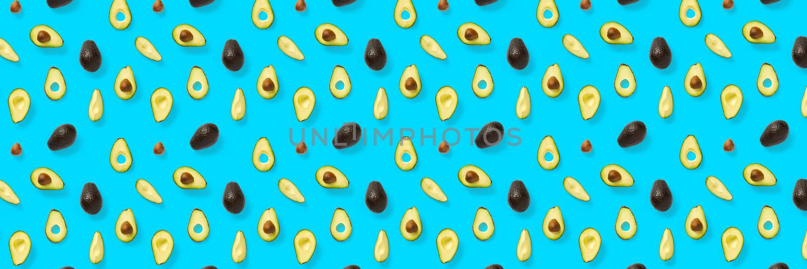 Avocado banner. Background made from isolated Avocado pieces on blue background. Flat lay of fresh ripe avocados and avacado pieces