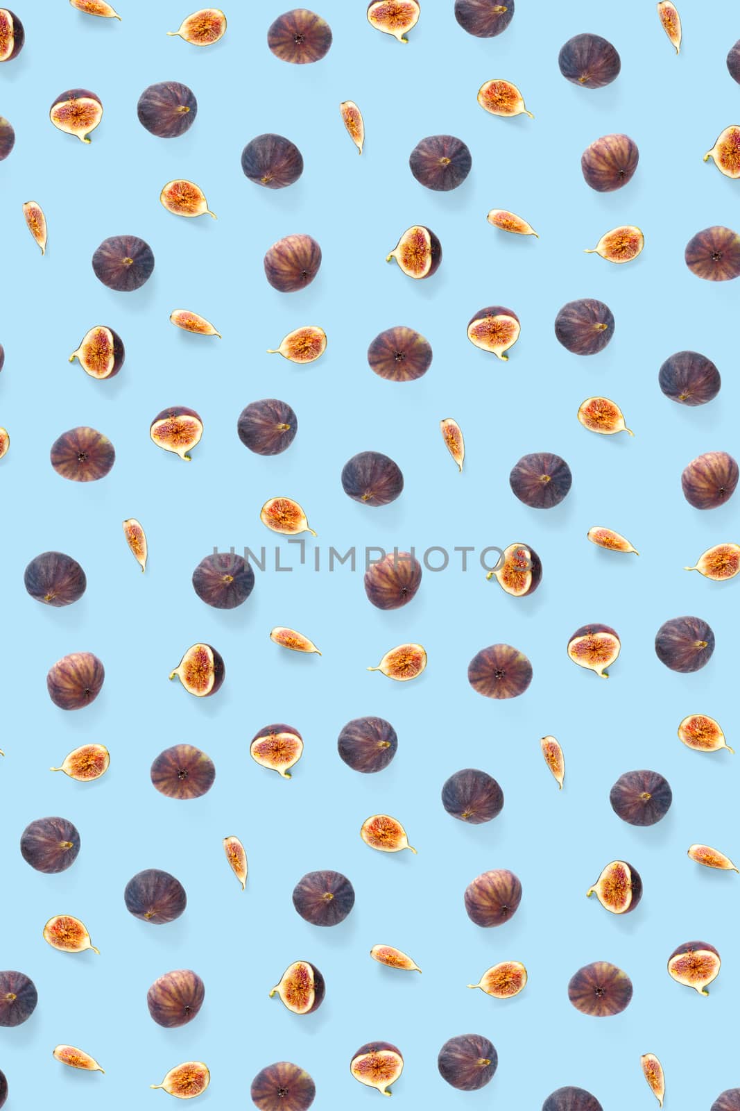 Background from Fresh figs. Food Photo. Modern fig fruits background. Creative set of the whole and sliced figs on a blue background, not pattern
