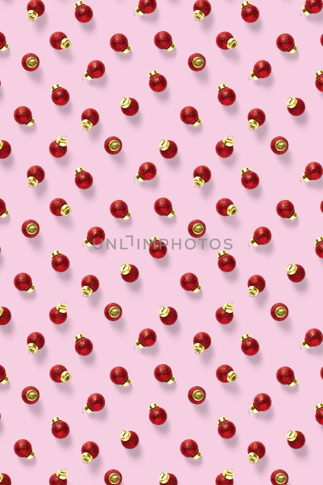 Christmas red decorations on pink background. Christmas ornaments composition for background. Flat lay background madefrome red ornaments decorations