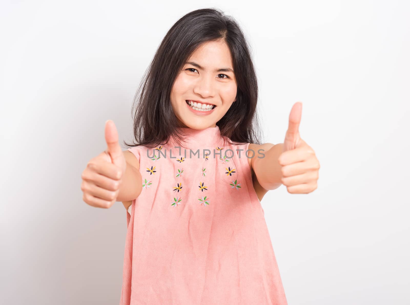 Portrait Asian beautiful young woman standing, She made finger thumbs up, Ok sign to agree and looking at camera, shoot photo in studio on white background, There was copy space