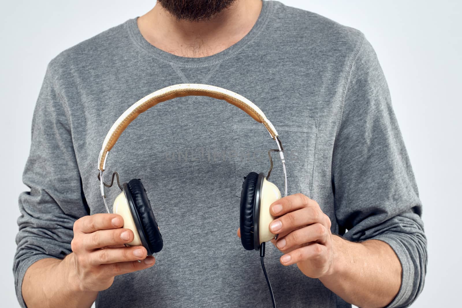 Man holding headphones in the hands of a man lifestyle modern style technology cropped view. High quality photo