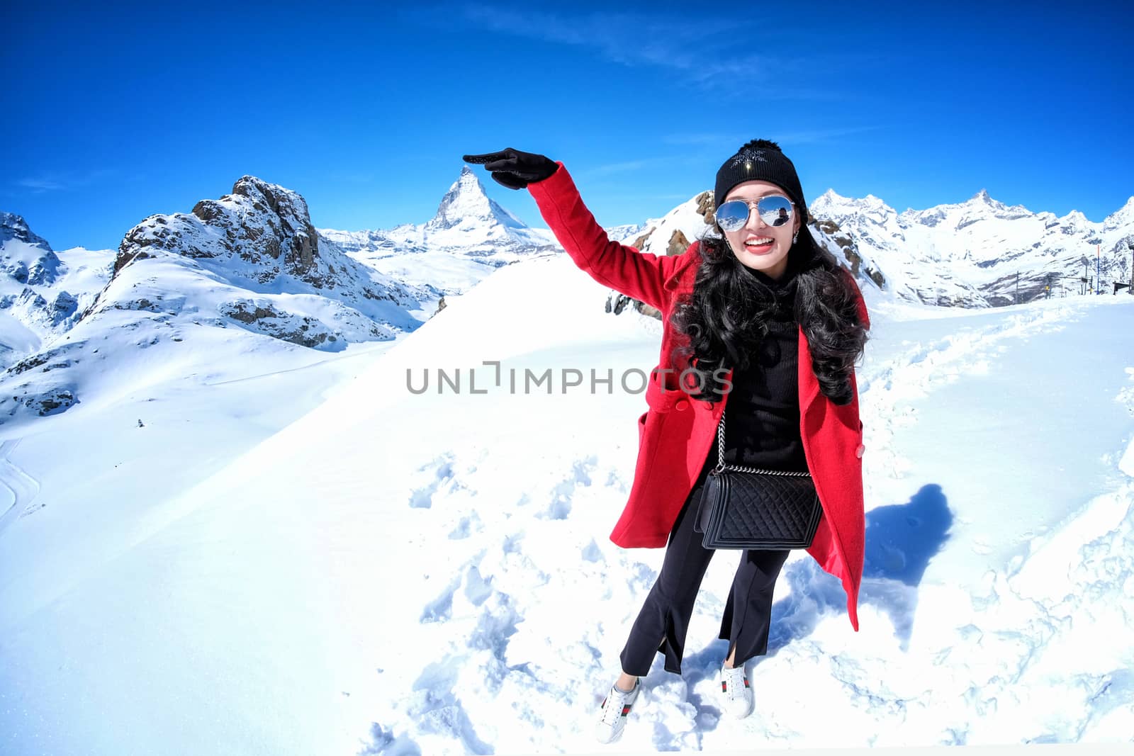 Young Woman Tourists see beautiful view of snow mountain Matterhorn peak, Zermatt, Switzerland.