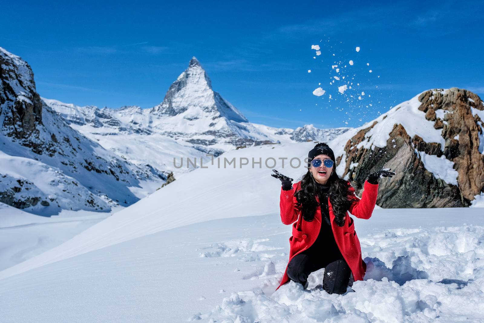 Young Woman Tourists playing snow in mountain Matterhorn peak, Zermatt, Switzerland.
