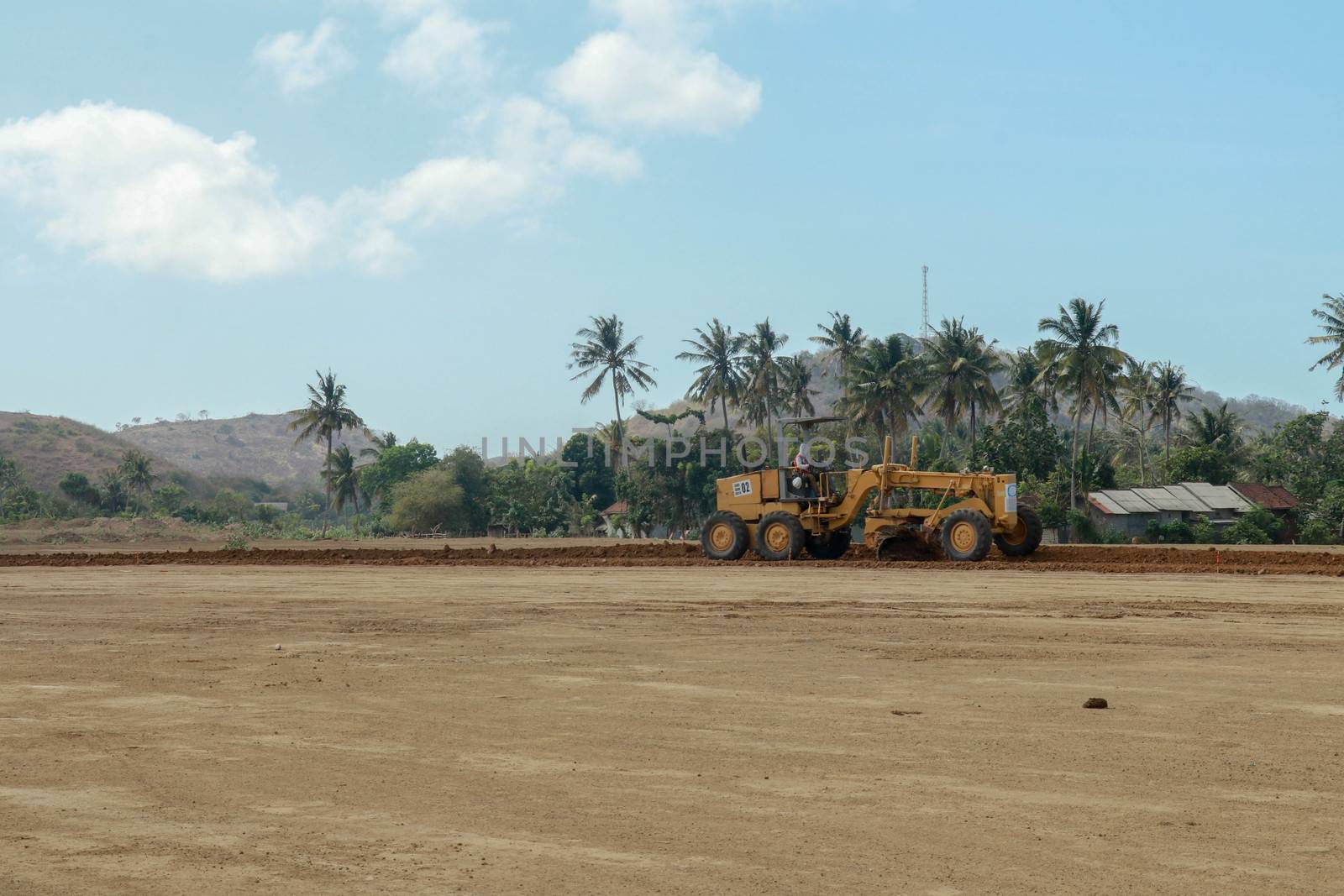 Working machines and heavy equipment adjust the terrain of the race track. Construction of the area and the Moto GP Mandalika racing circuit, West Nusa Tenggara, Lombok, Indonesia. Building a racetrack for motorcycles.