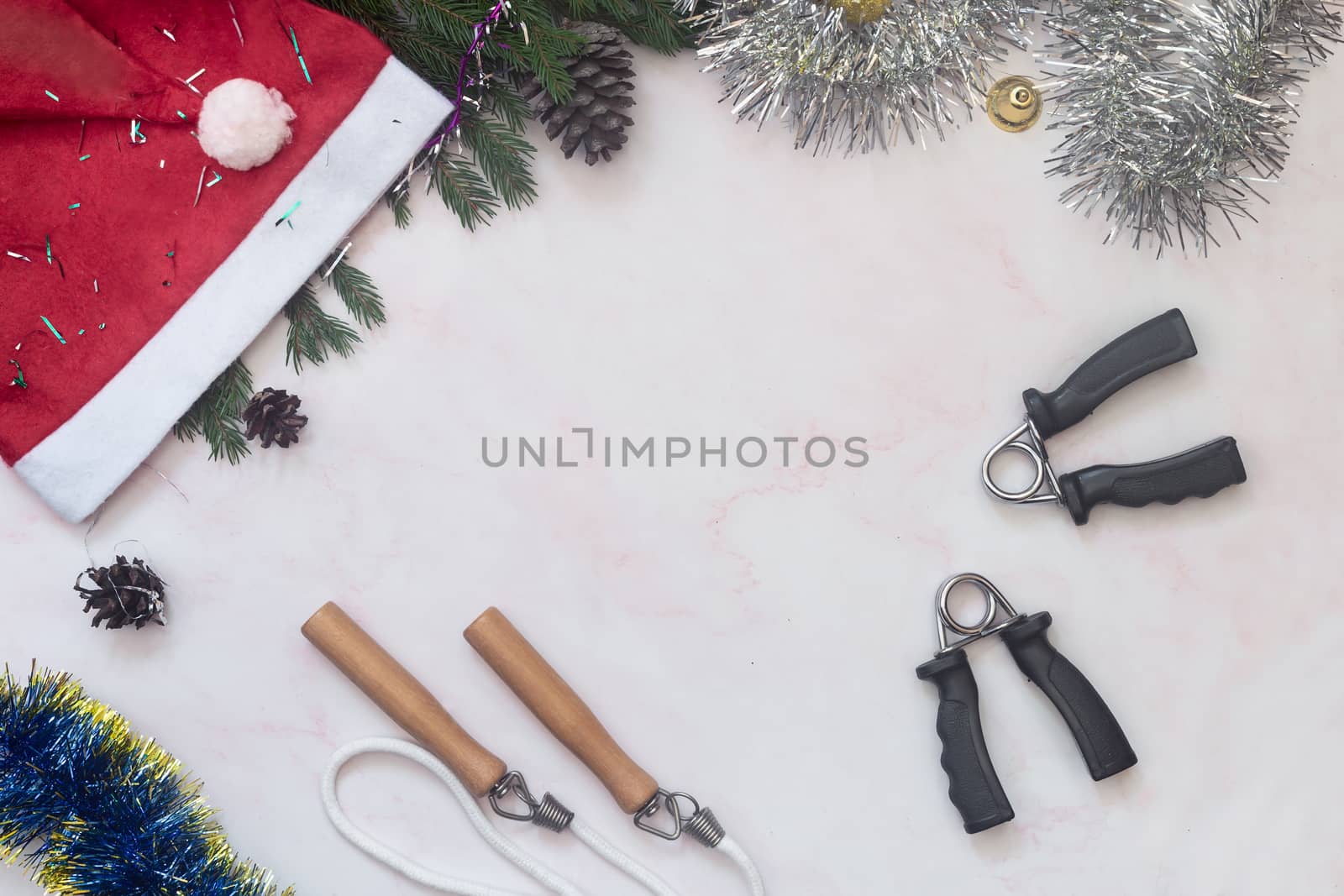 Set of expanders and Christmas decorations on a light background. Greeting card with the concept of a healthy lifestyle. Sports and fitness. Top view with space to copy. Flat lay.