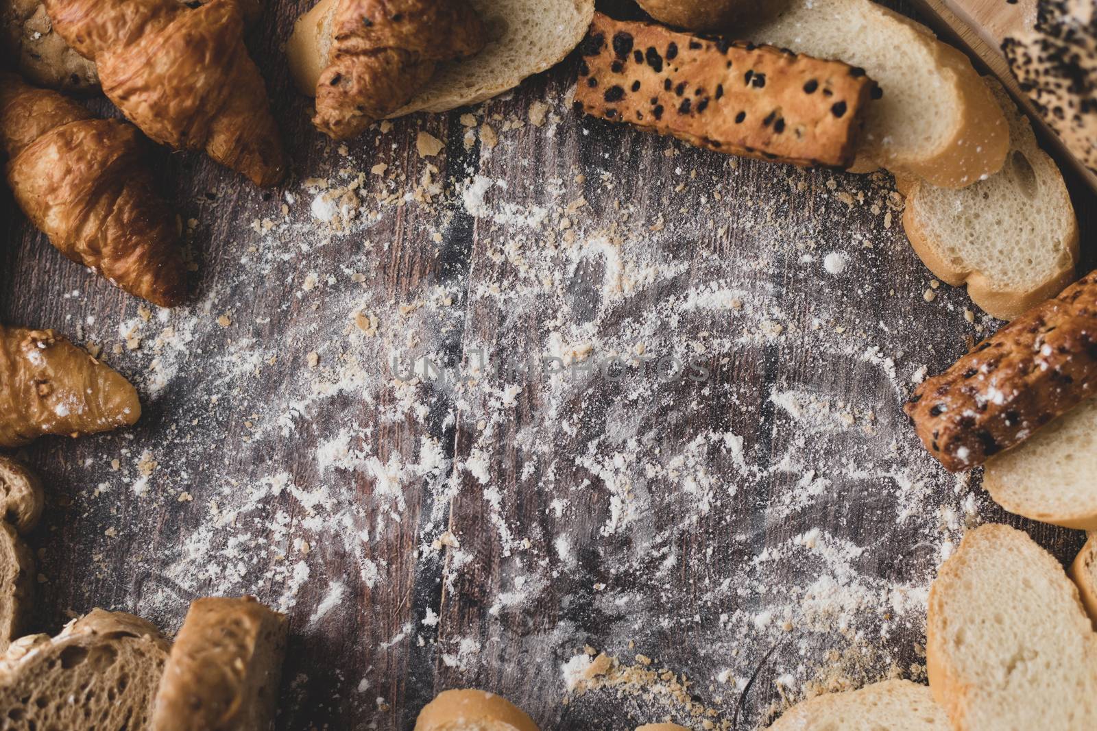 Bread and pastry powder on a wooden table by Nikkikii