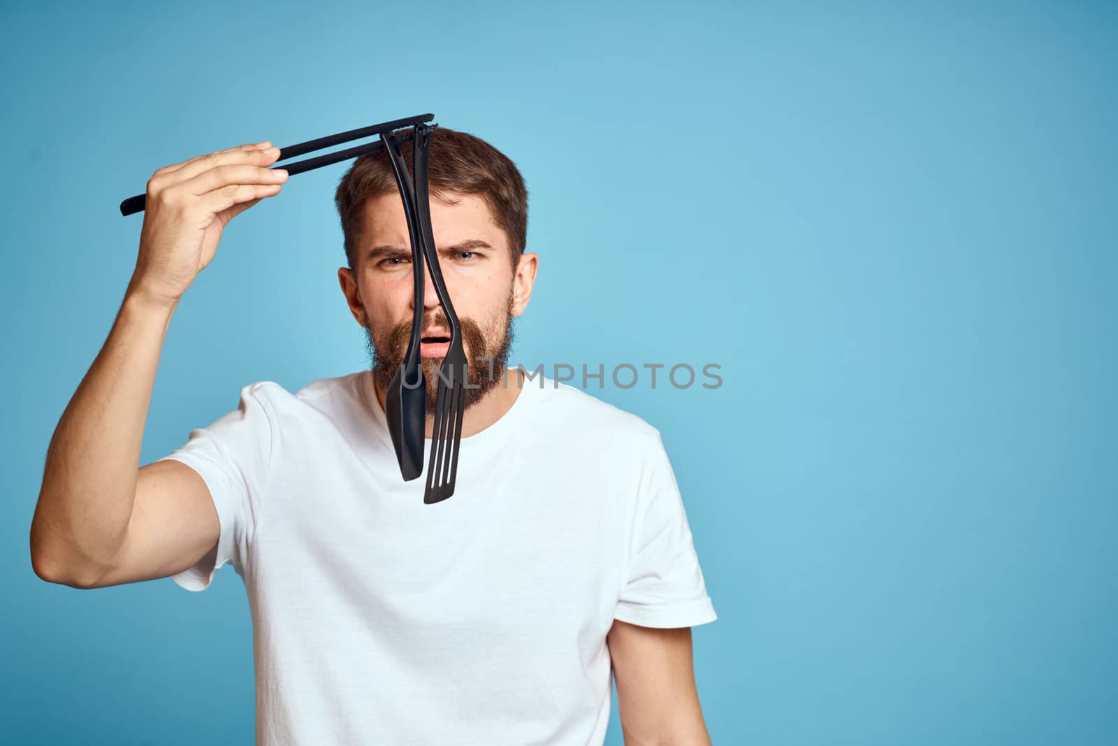 Bearded man with tools for cooking on a blue background and a white T-shirt shovel by SHOTPRIME