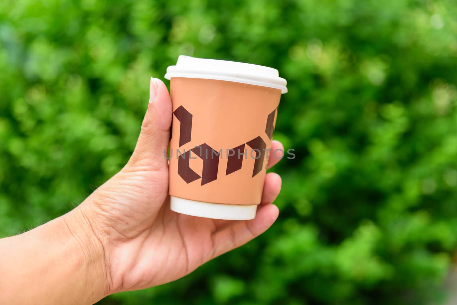 Bangkok, Thailand - 16 September, 2020:  The man hand show a cup of hot coffee of NANA Hunter Coffee Roasters 

coffee brand