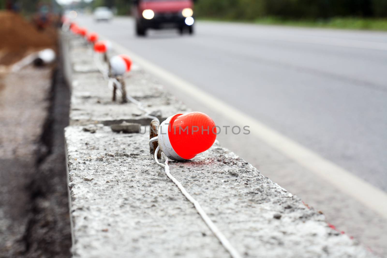 Repair of roads. Concrete road fence on background with car