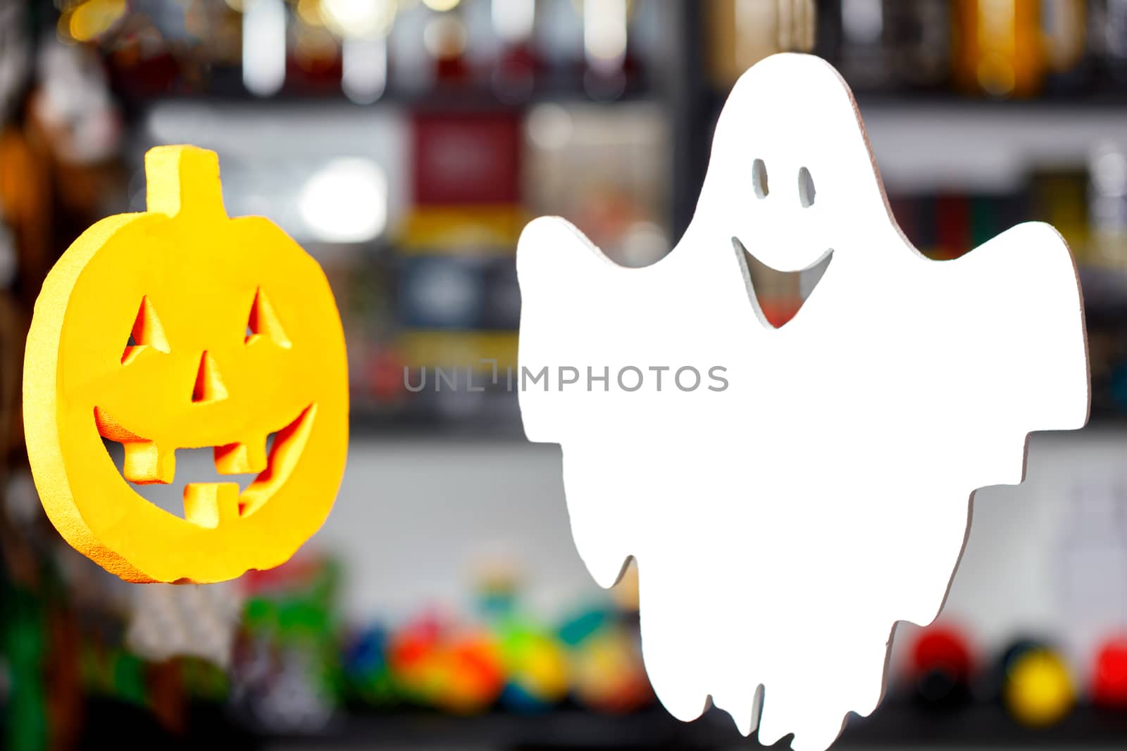 Halloween, two soaring merry ghosts in the form of a pumpkin head and a white ghost on a blurred background.