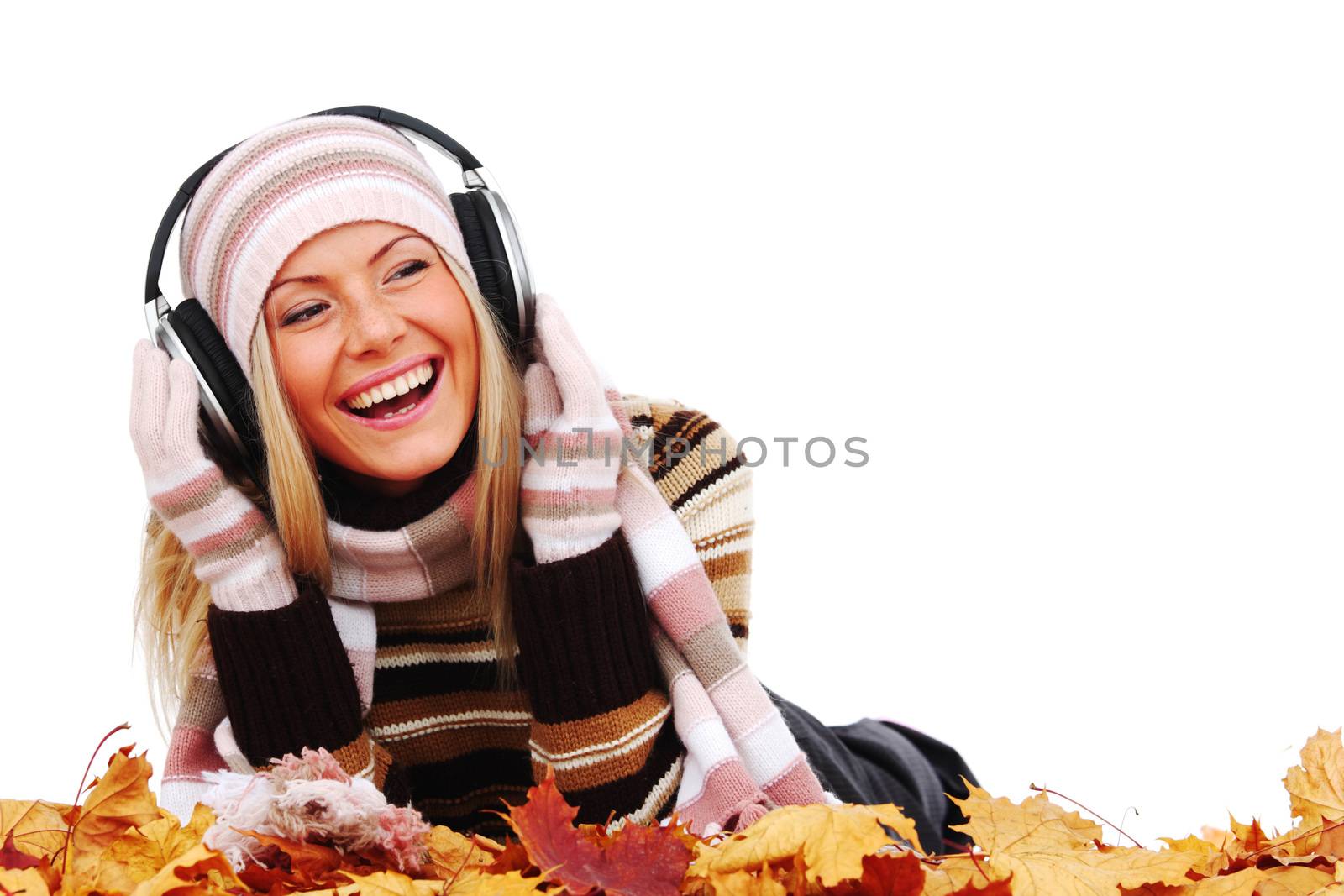 autumn woman listening music lying in autumn dry maple leaves studio isolated on white background