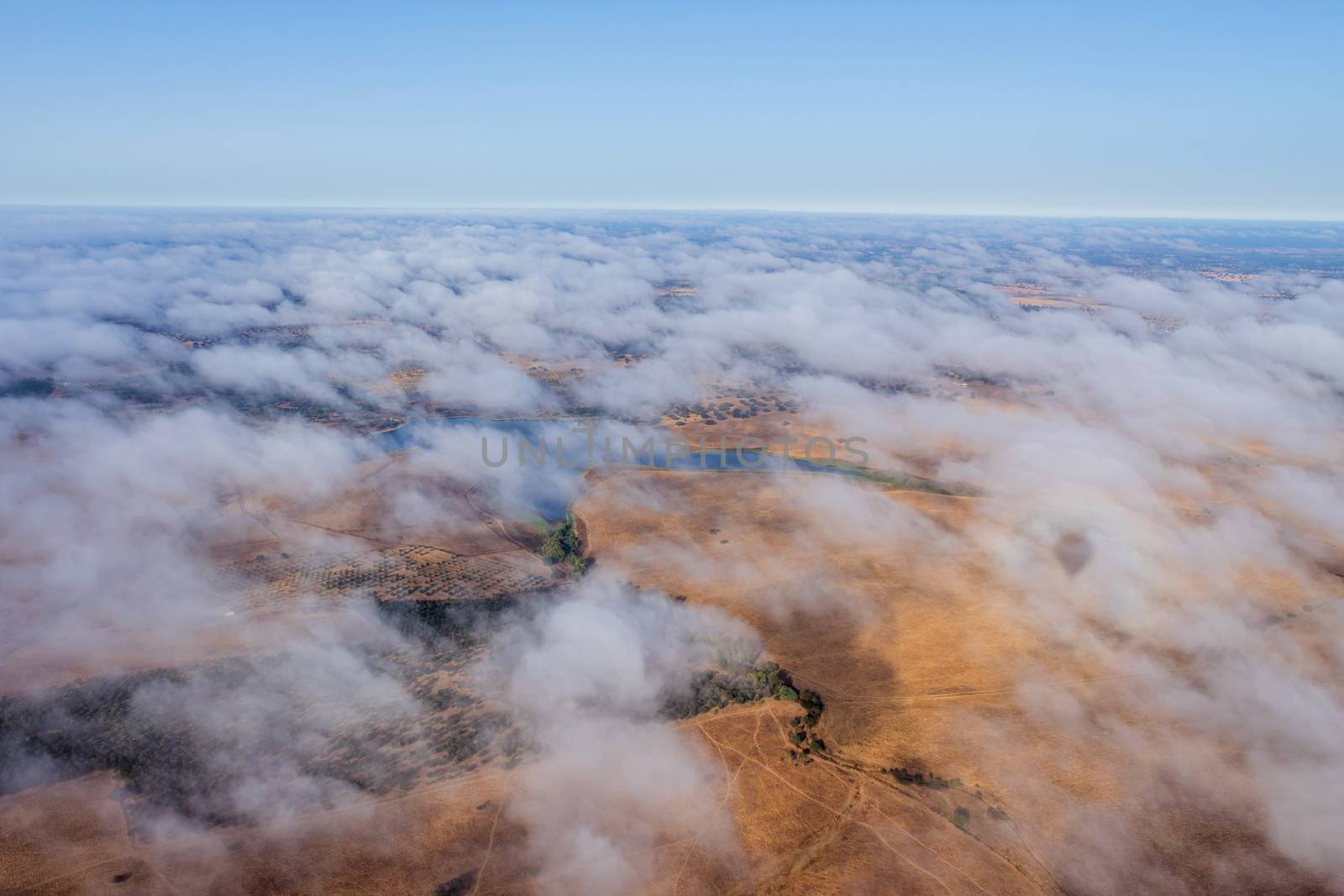 Hot air balloon in the Alentejo region, above the clouds and the fields. Portugal.