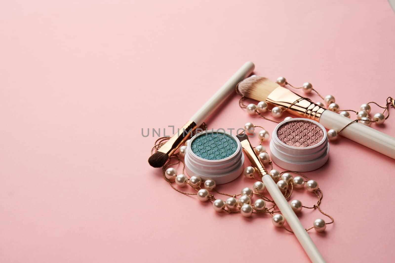 eyeshadow accessories beads makeup brushes collection professional cosmetics on pink background by SHOTPRIME