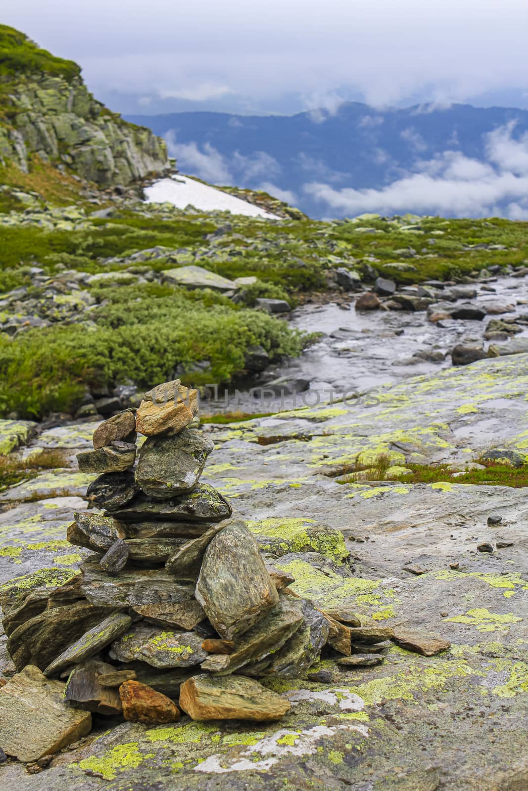 Stacked stones by the Hydnefossen waterfall and Hydna river on Veslehødn Veslehorn mountain in Hemsedal, Norway.