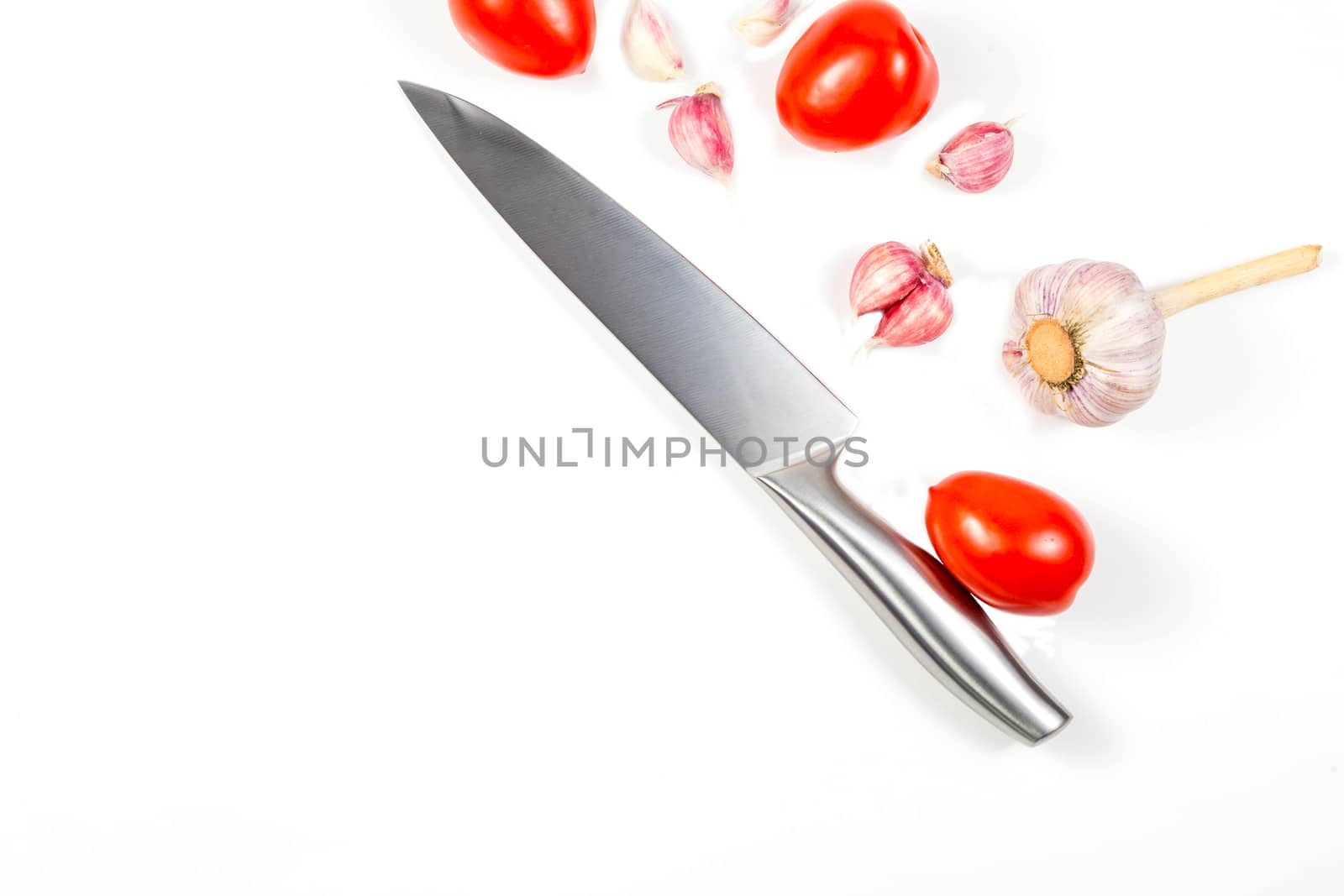 Closeup image of chief knife garlic tomato by galinasharapova