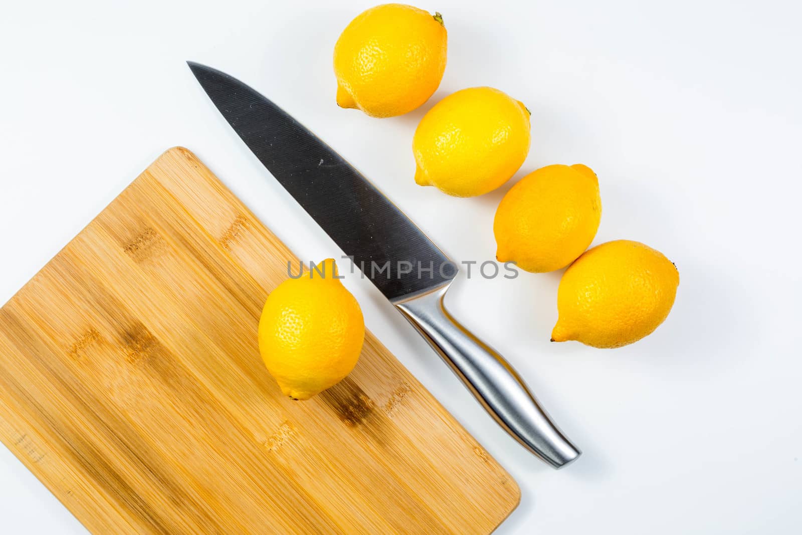 Closeup image of chief knife and lemon on white table