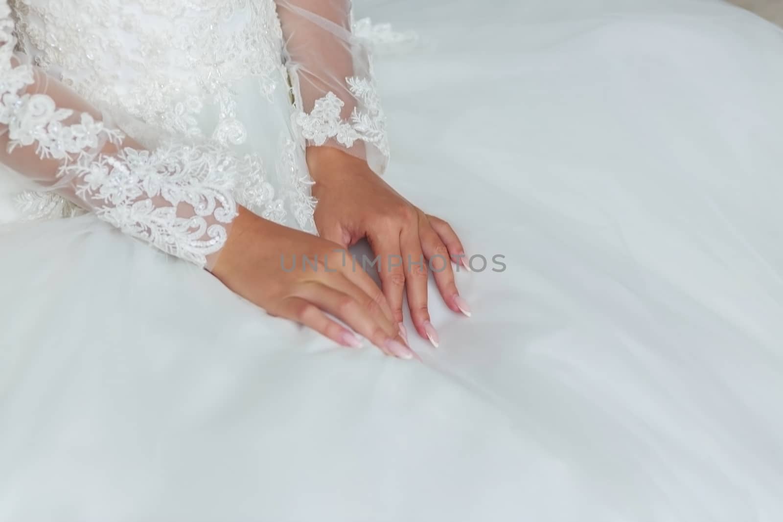 Bride's hands on a wedding dresswhite wedding dress.