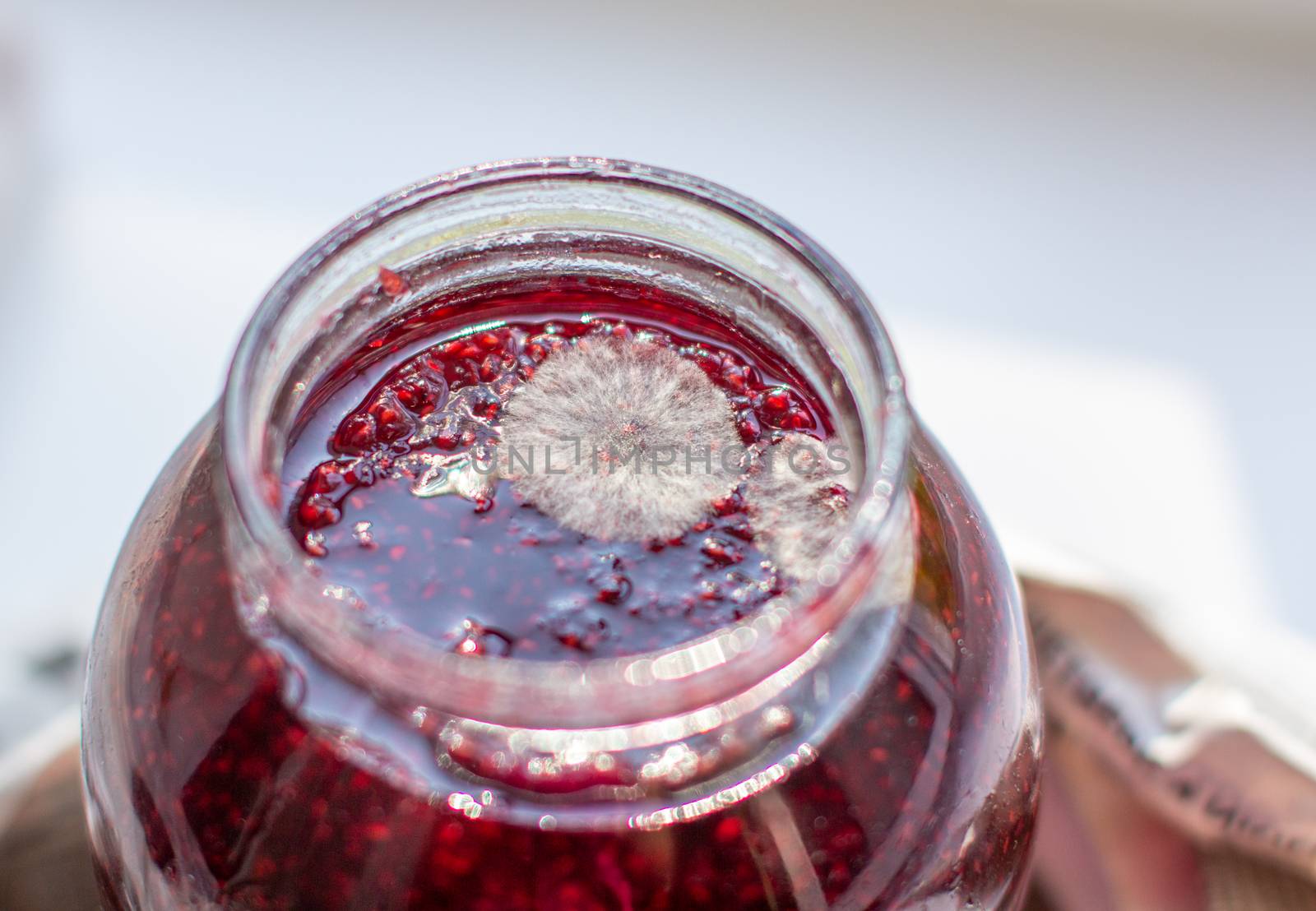 Mold in a jar of raspberry jam. Hazardous to health. Mold. High quality photo