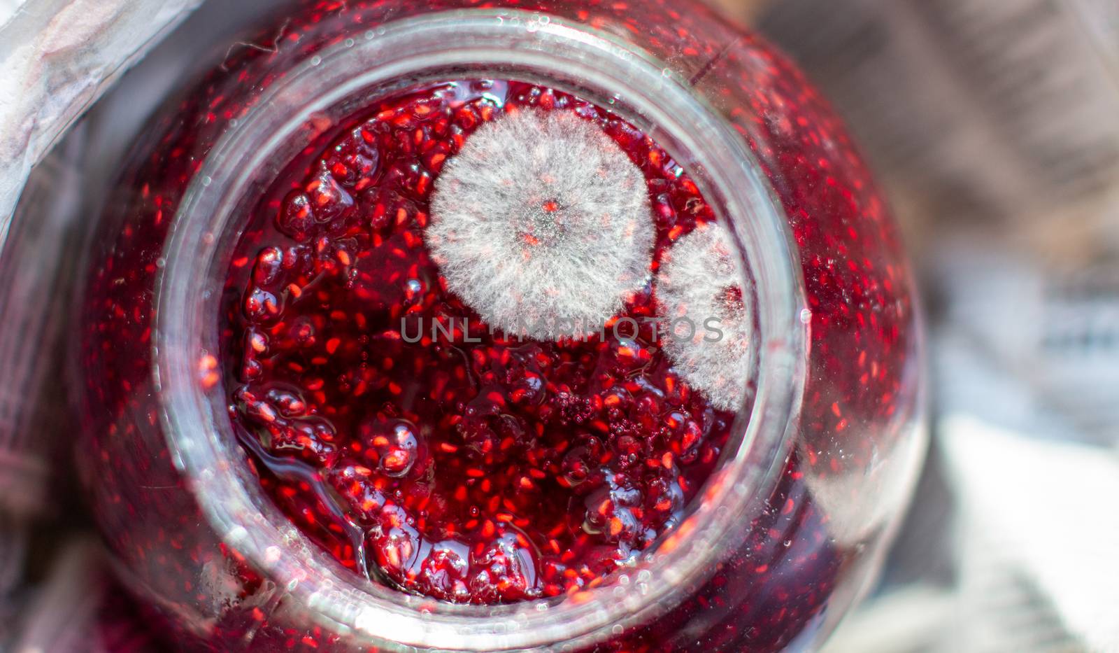 Mold in a jar of raspberry jam. Hazardous to health. Mold. High quality photo