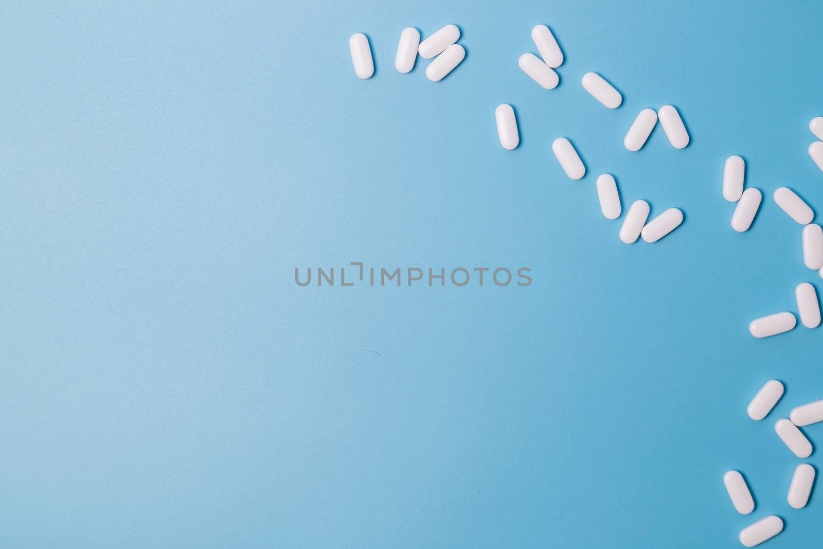 pills or vitamin tablets on the blue background, copy space for text.