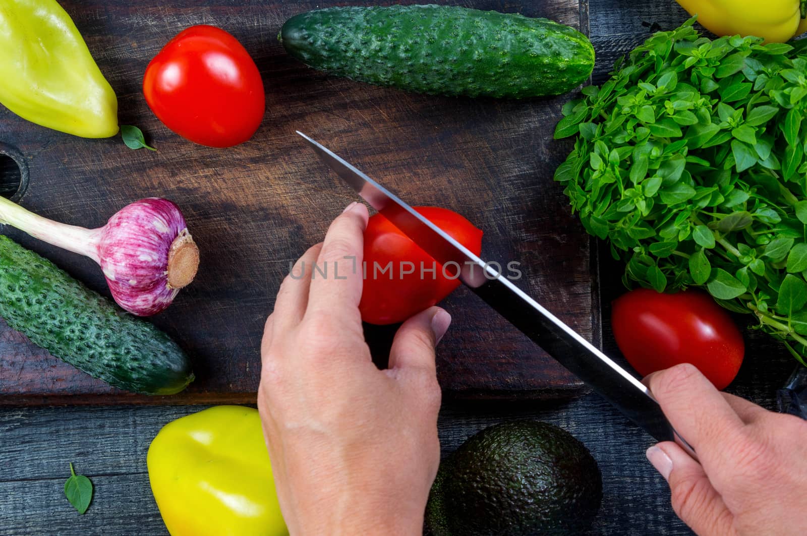 Closeup image of a woman cutting and chopping tomato by galinasharapova