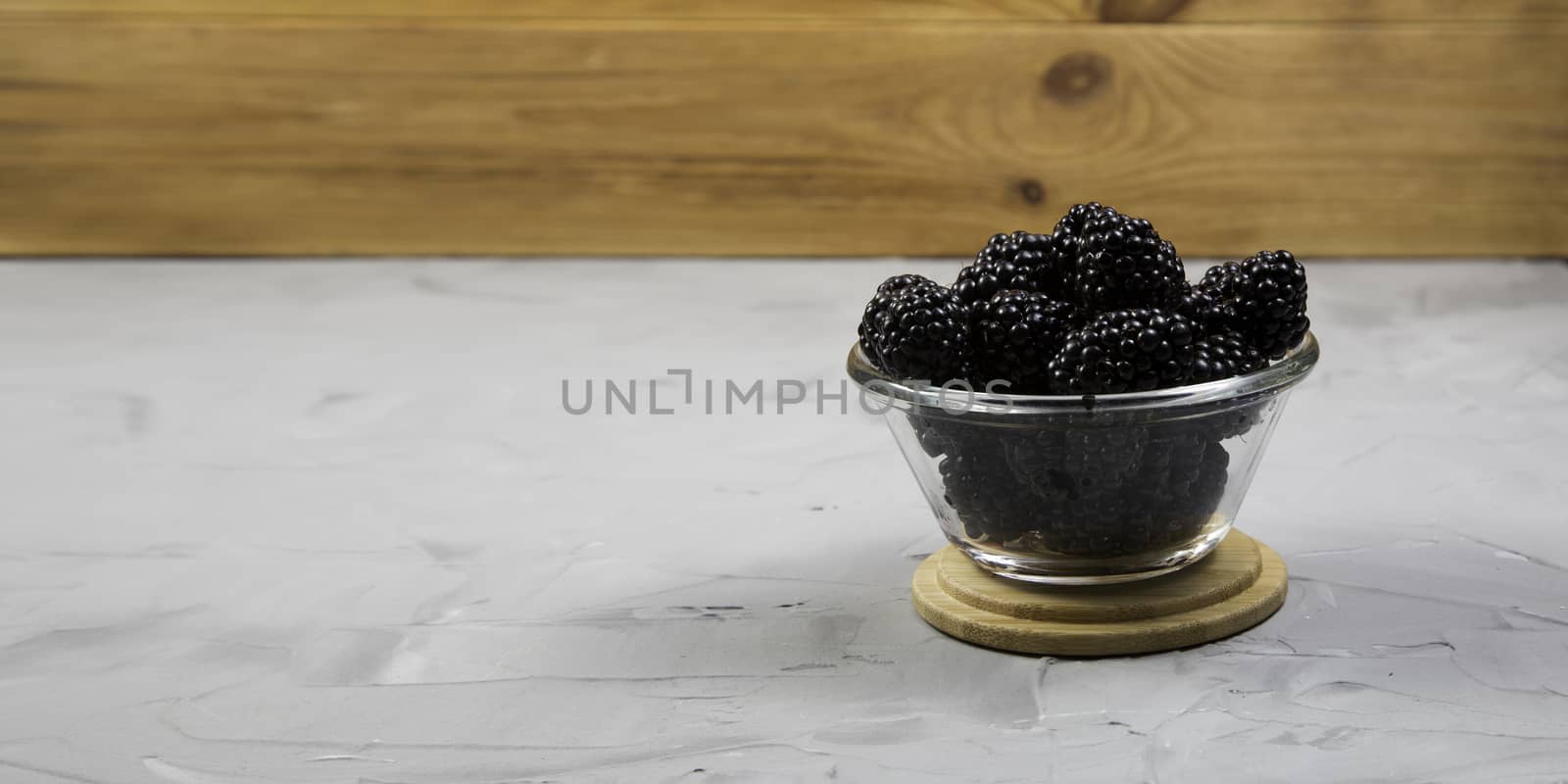 ripe blackberry with leaves on a concrete background, rustic, place for text, banner