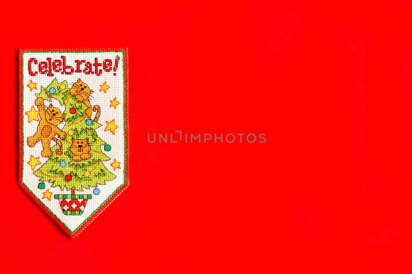Christmas background with embroidered new year flag on red background, holiday, new year and Christmas concept. holiday. cats on the Christmas tree, a fun holiday picture.