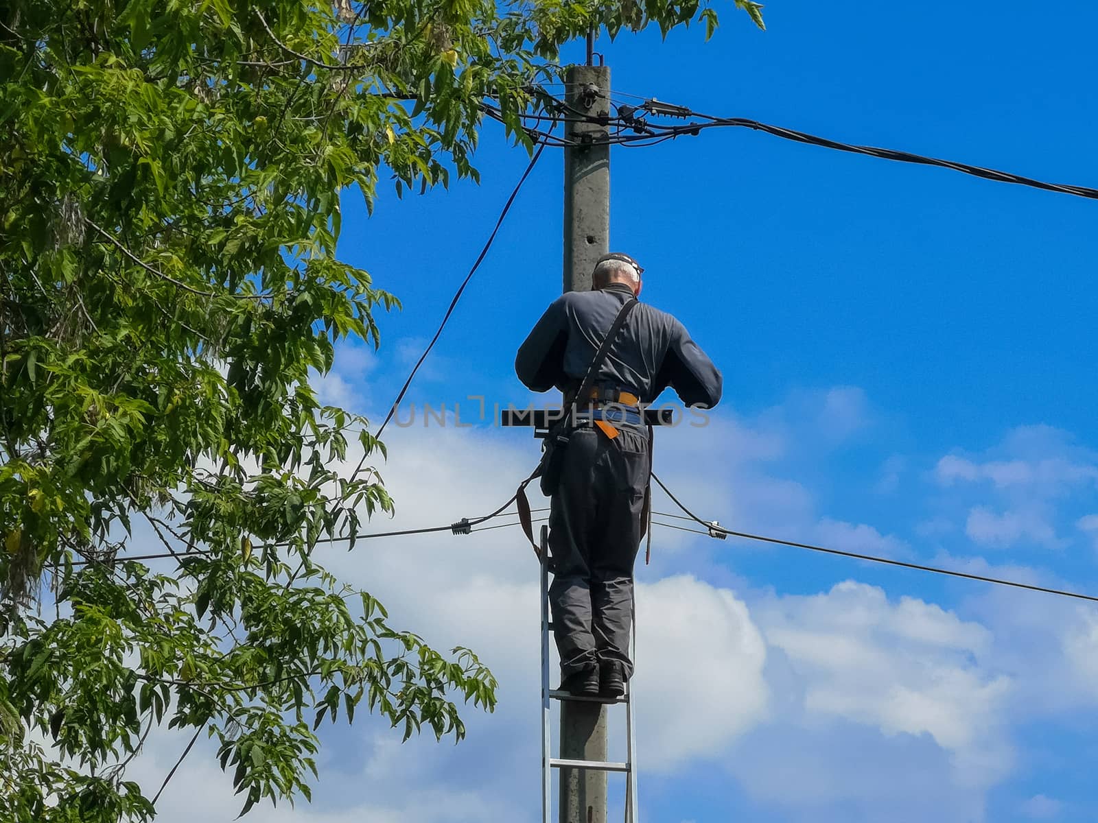 Electrician repairing,electricians repairing wire on electric power pole, power linesman climb the pole.It's a dangerous job.