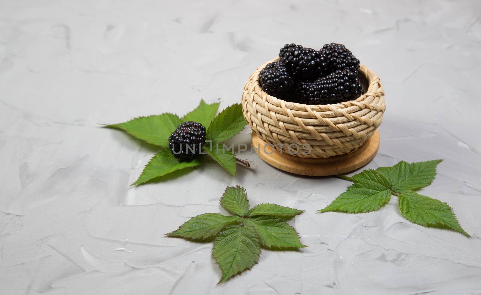 Ripe sweet blackberry with leafs on gray concrete backgroun by galinasharapova