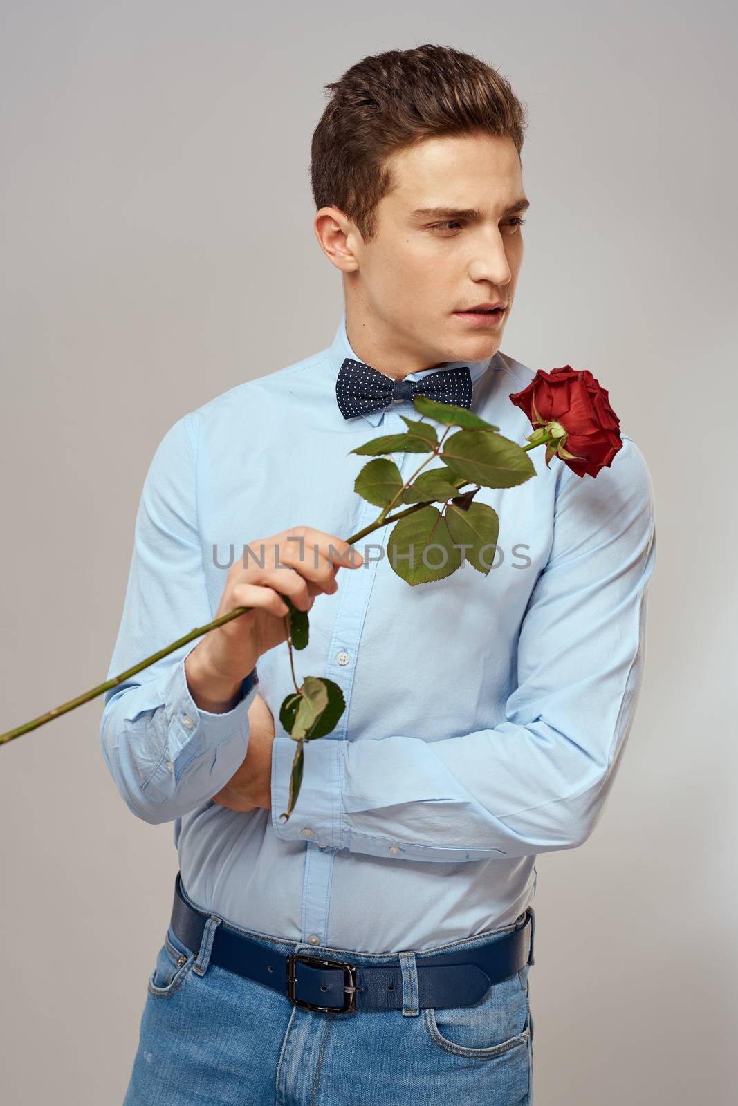 romantic man with red rose and light shirt pants suit. High quality photo